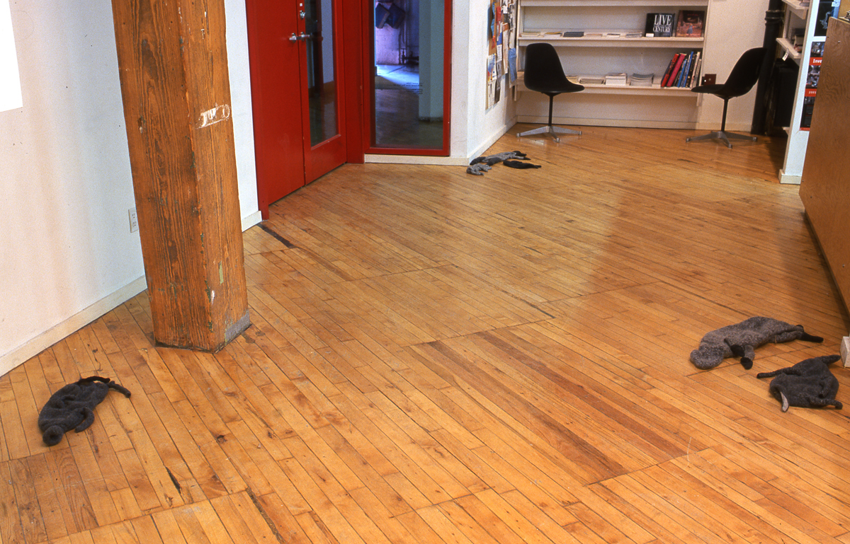 Installation view of the group show trophy, knit animals arranged on the gallery floor.
