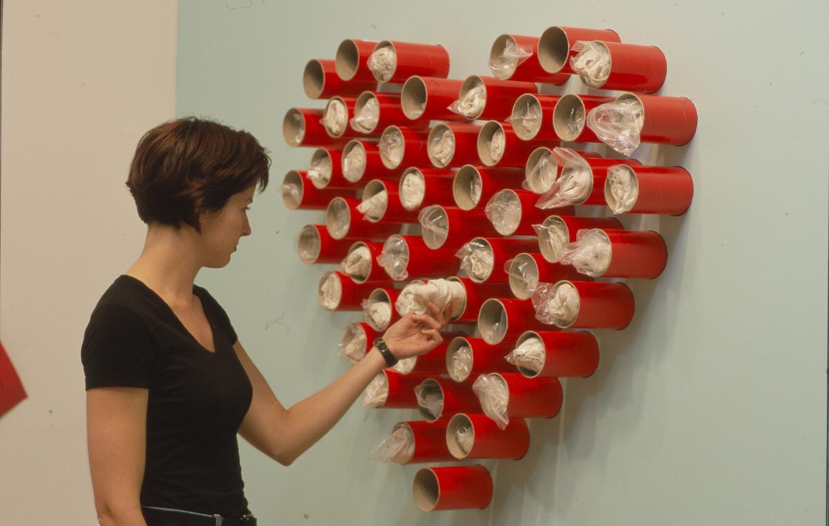 Clara Ursitti: Installation View, woman interacting with heart sculpture.