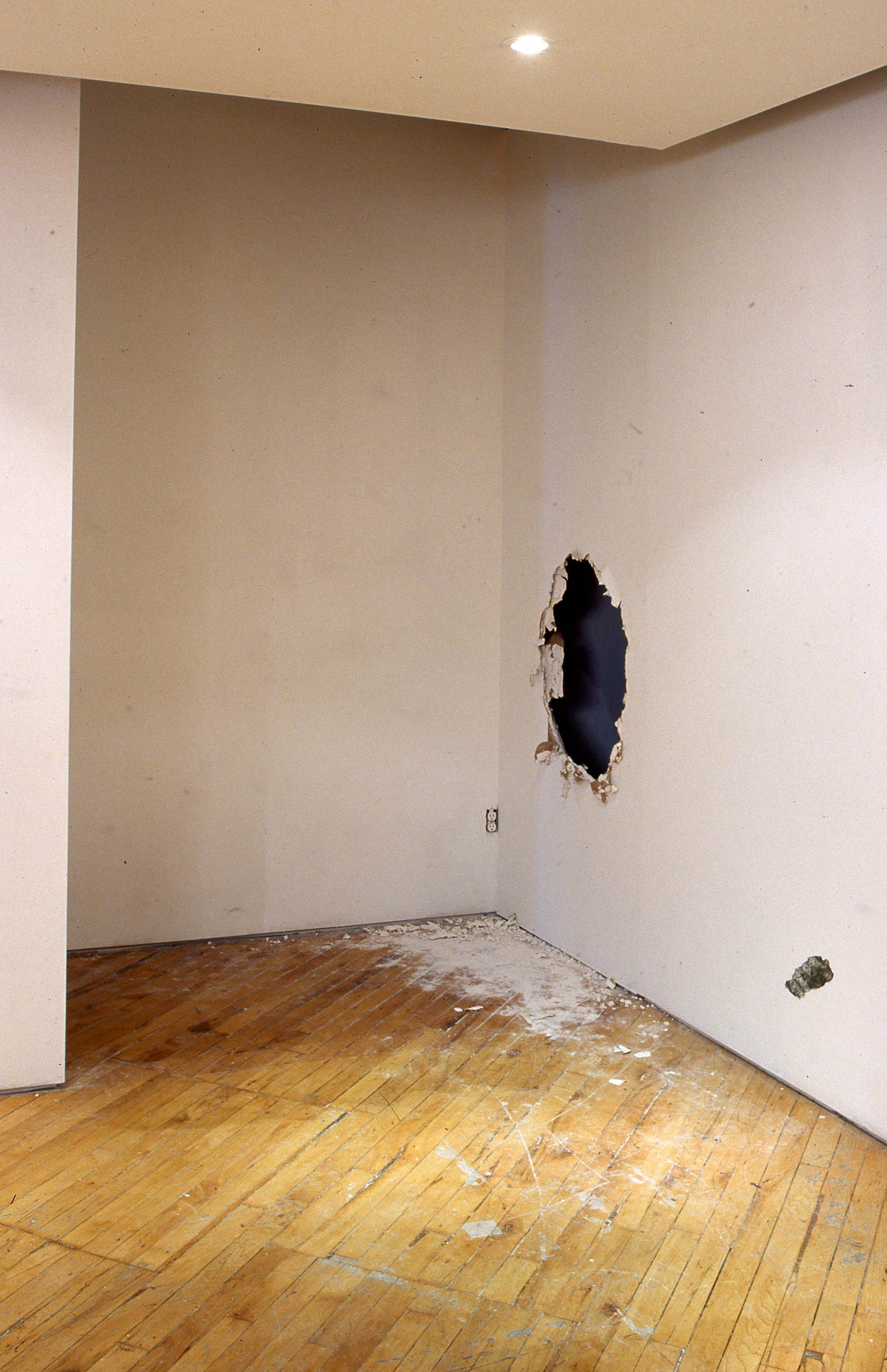 Emanuel Licha:View of installation space, the viewer must crawl through a replica of a bombed wall to view the installation.