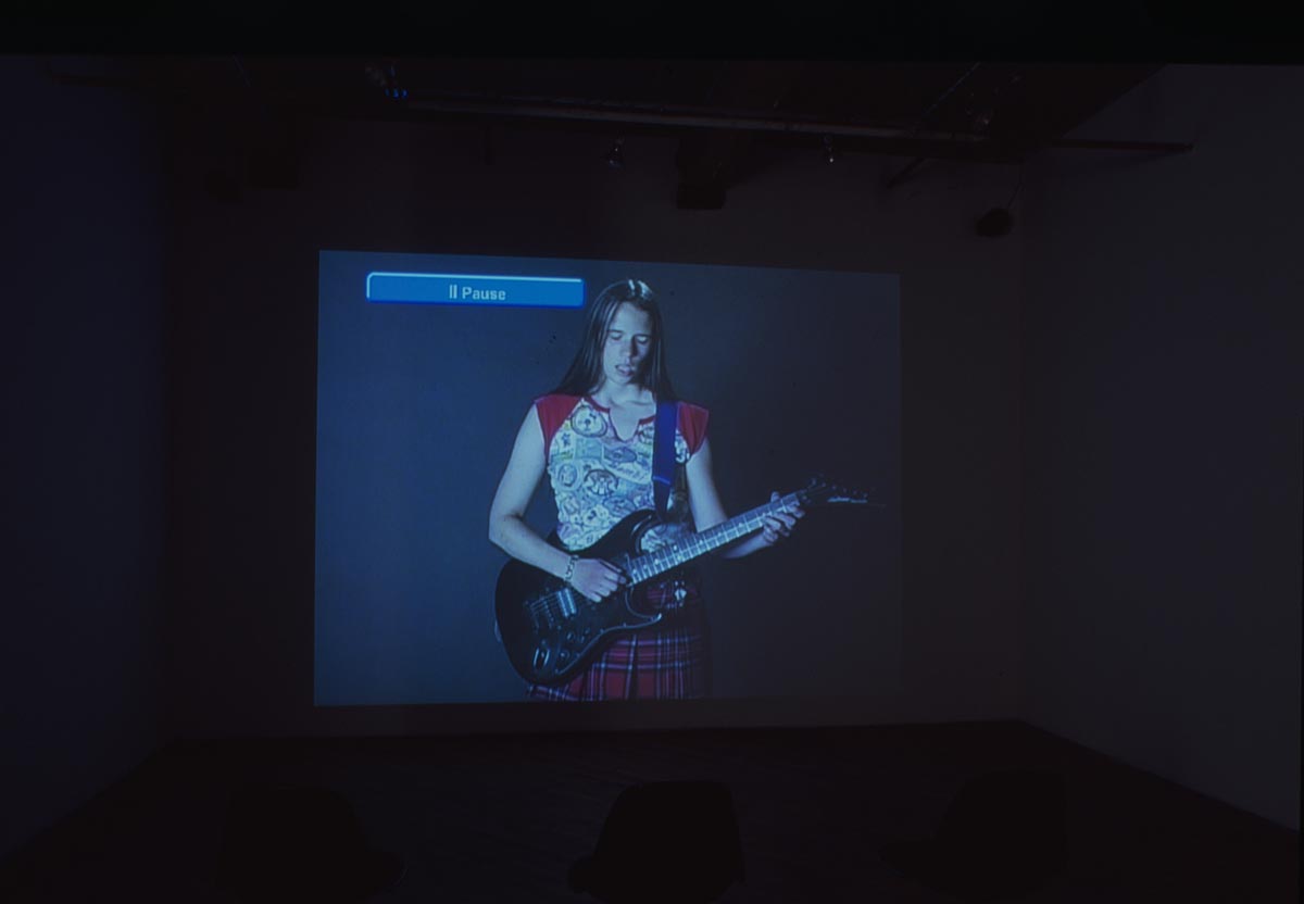 Projection of woman playing guitar.