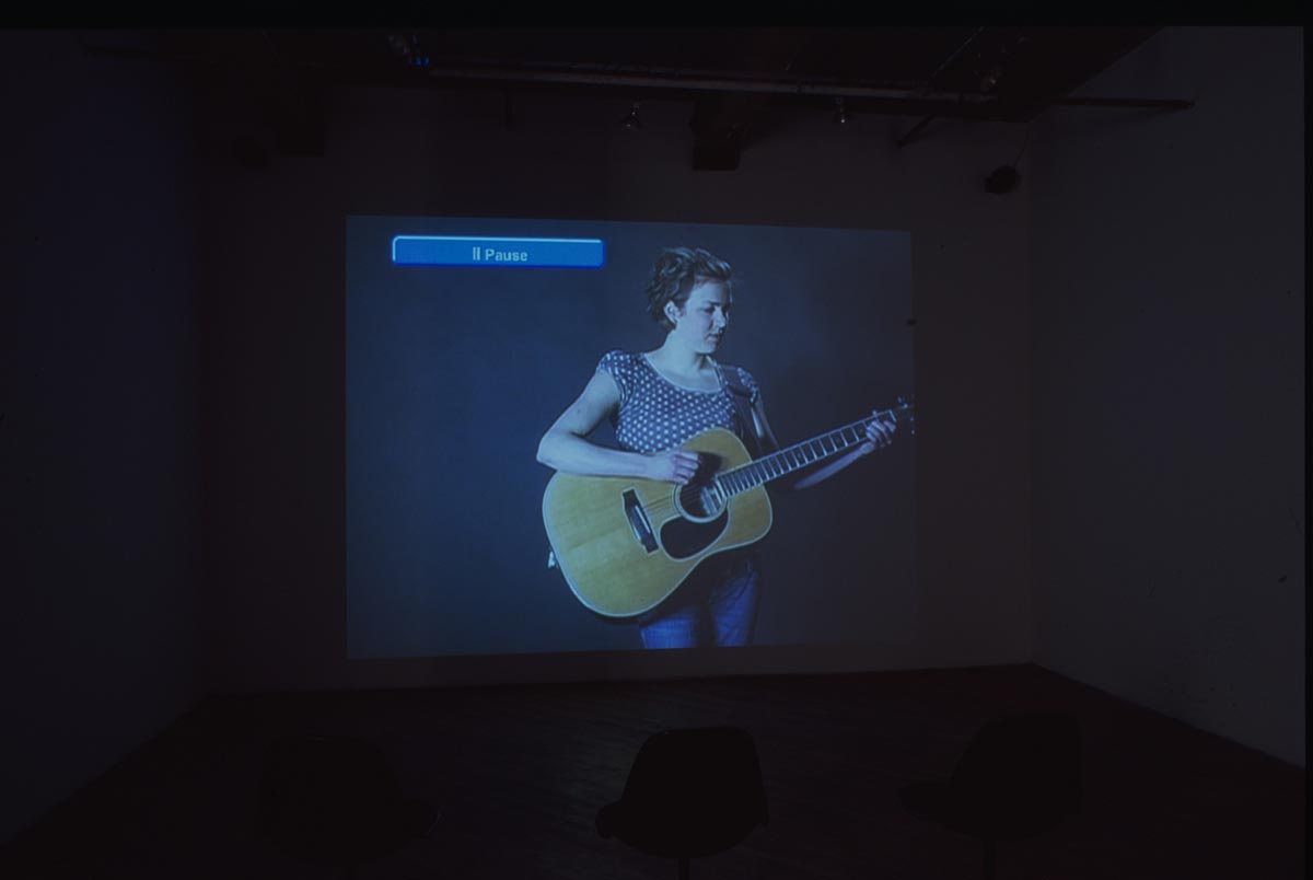 Projection of woman playing guitar.
