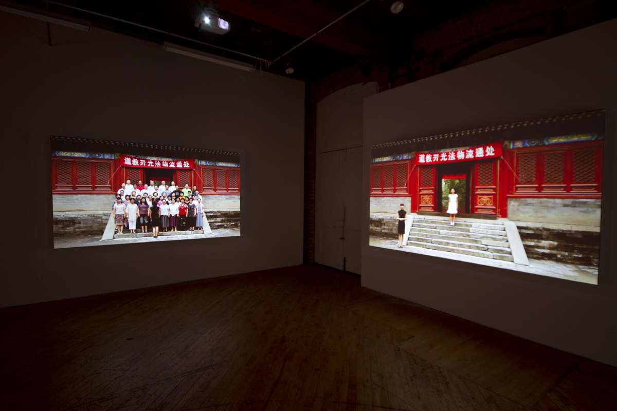 Installation view, projections of Chinese architecture, with image of person in the foreground.