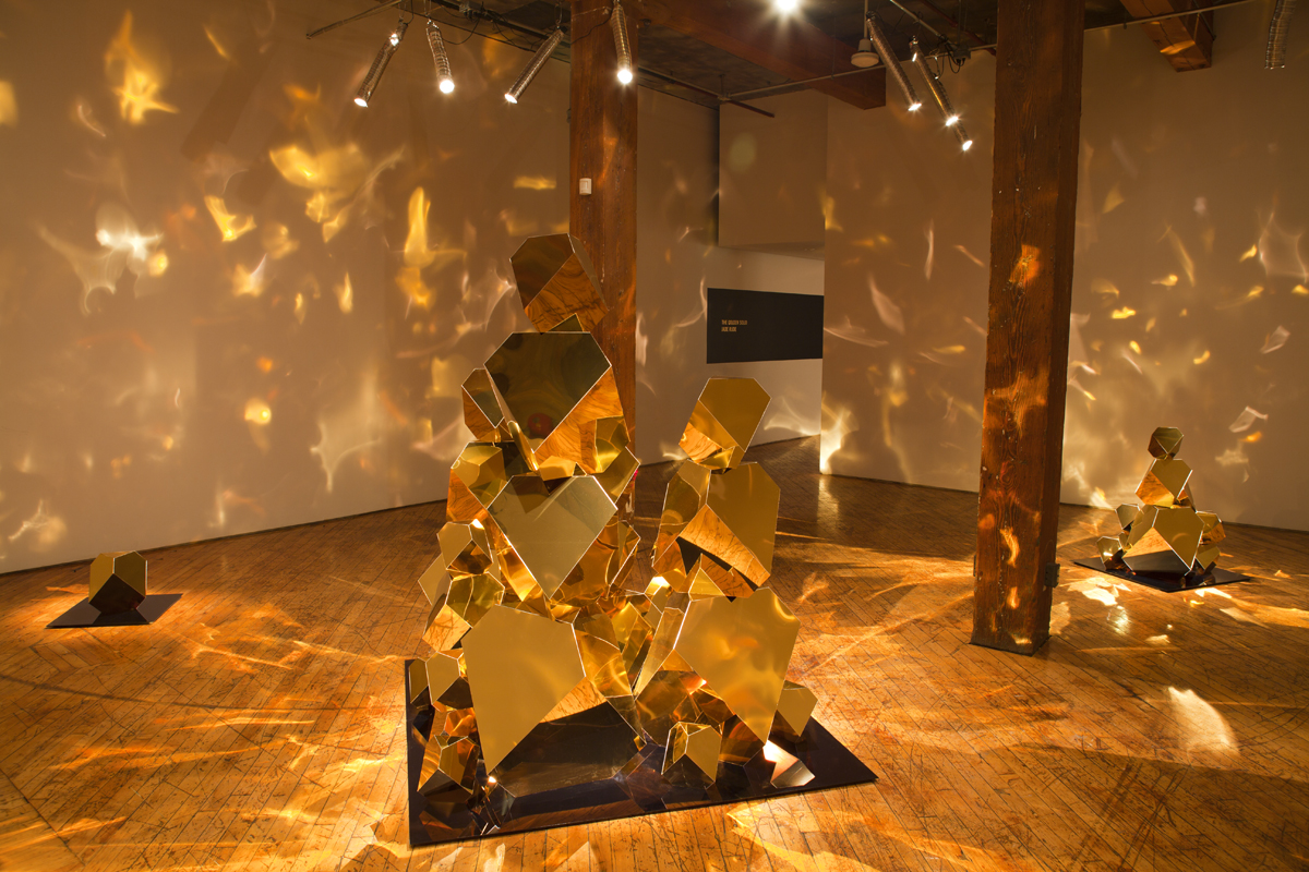 Jade Rude, installation view of gold sculpture with projected reflective lights.