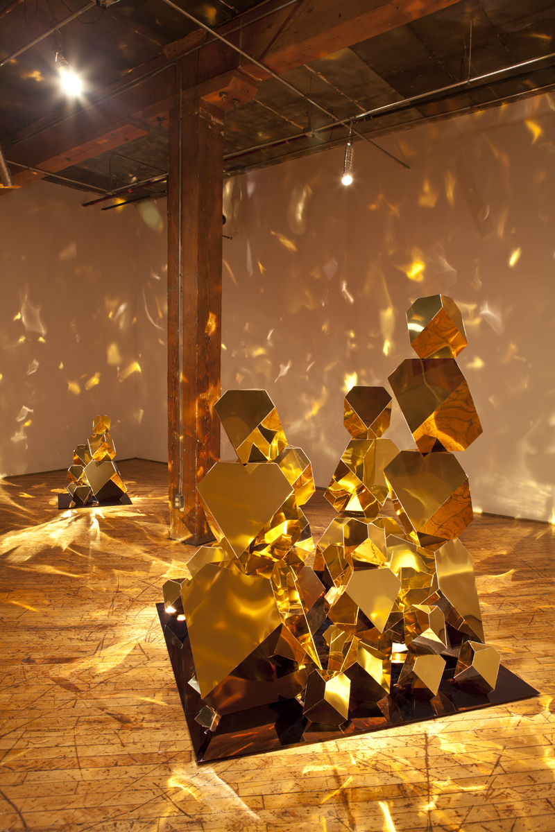 Jade Rude, installation view of gold sculpture with projected reflective lights.