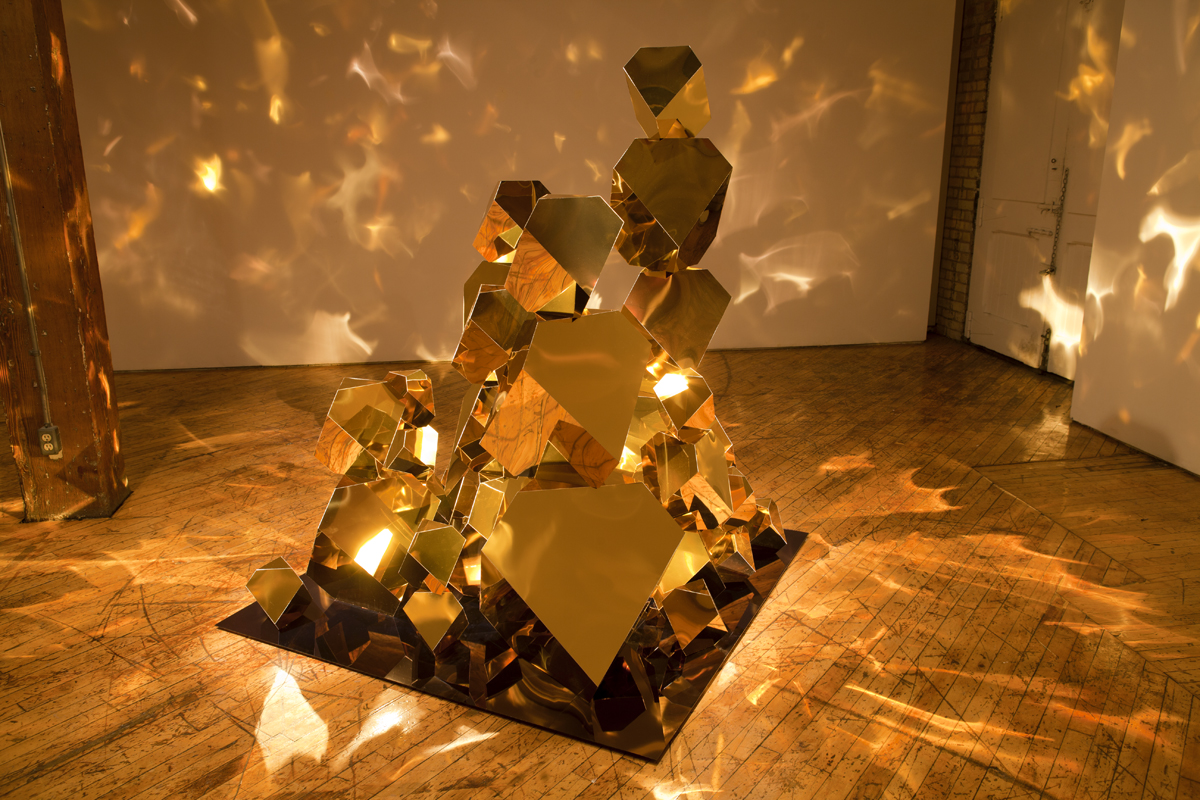 Jade Rude, installation view of gold sculpture with projected reflective lights.