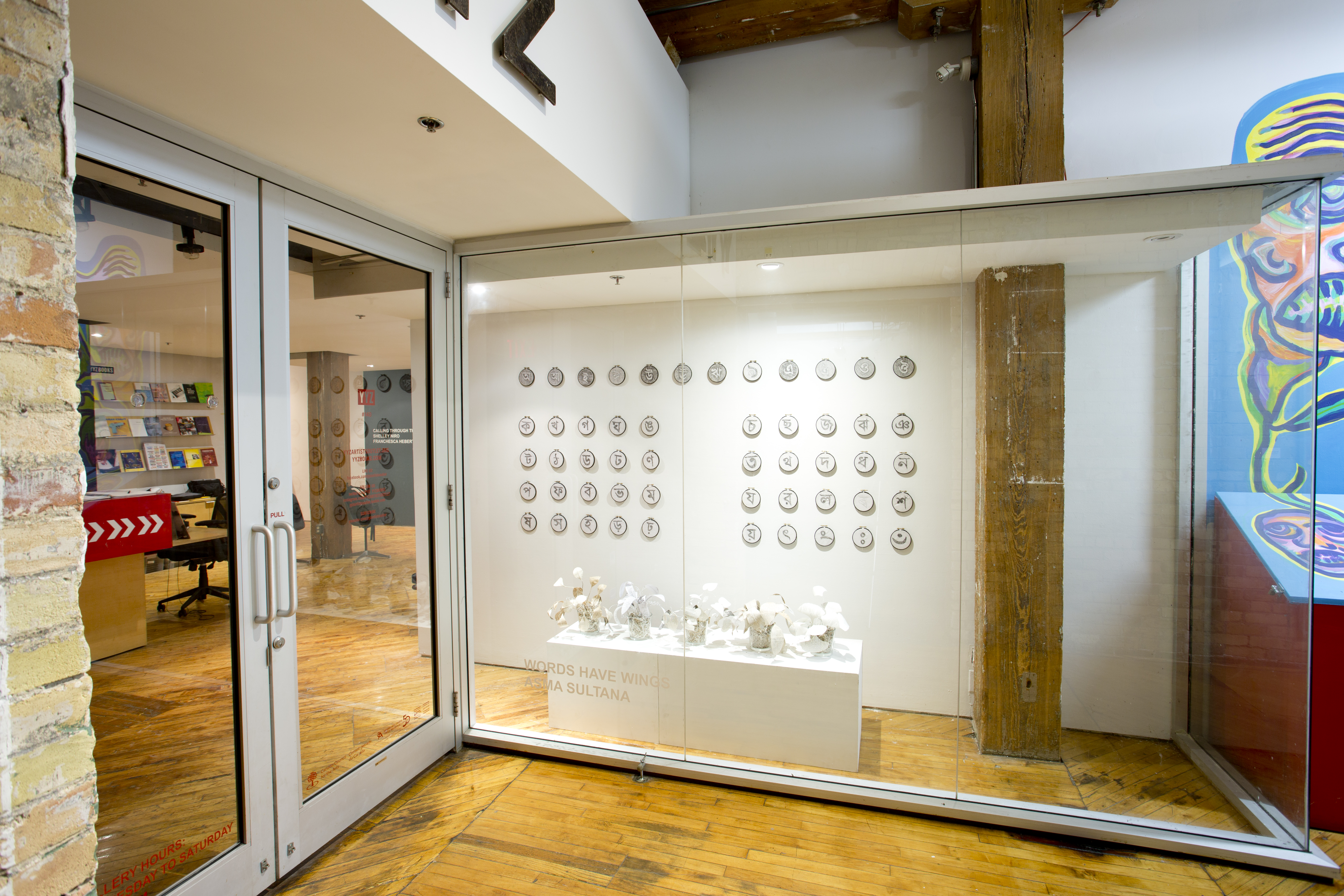 Asma Sultana, window installation, calligraphy symbols, created using hair crochet on mini circular canvases, displayed in rows.