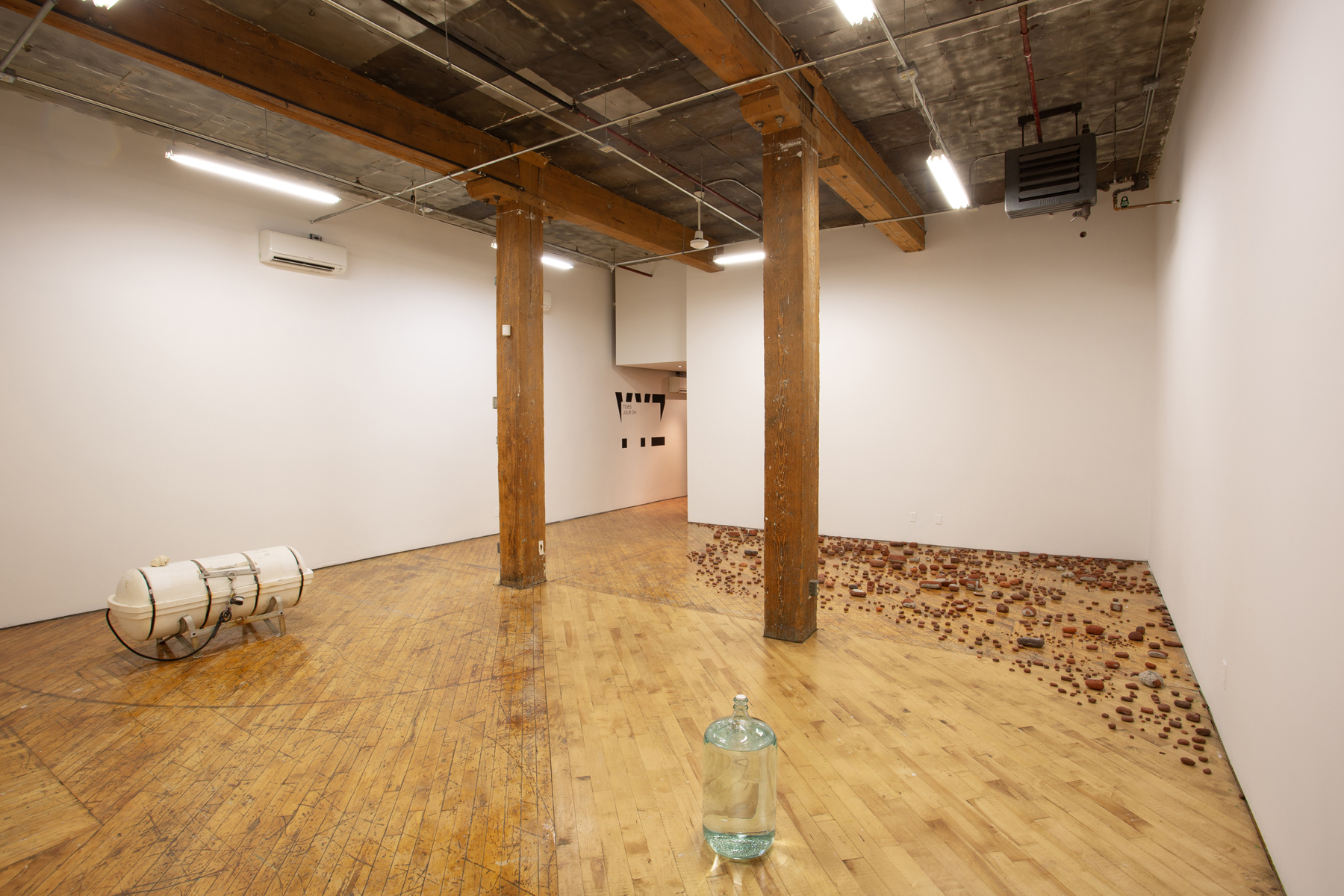 Julie Oh, installation, rocks on the ground, glass bottle, water tank.