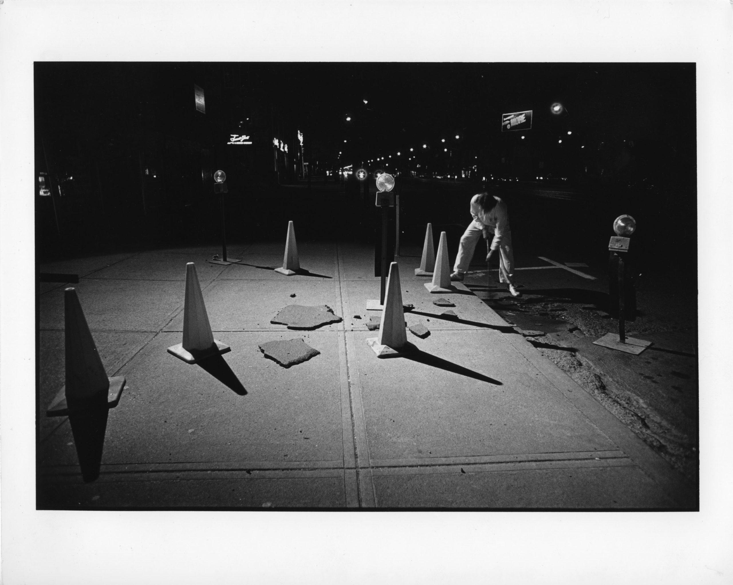 black and white photograph of sculptural art in an urban environment at night