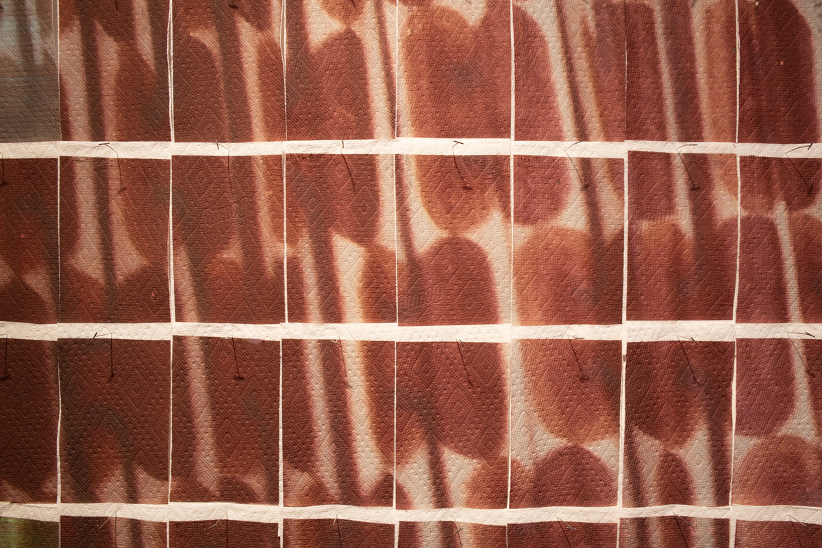 Jake Kimble: Installation view, large mural printed on paper towels, layer out in a grid formation, detail image.