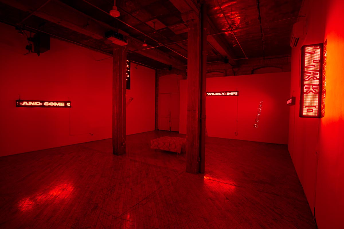 Installation View, red room, dim lights, with LED signs.