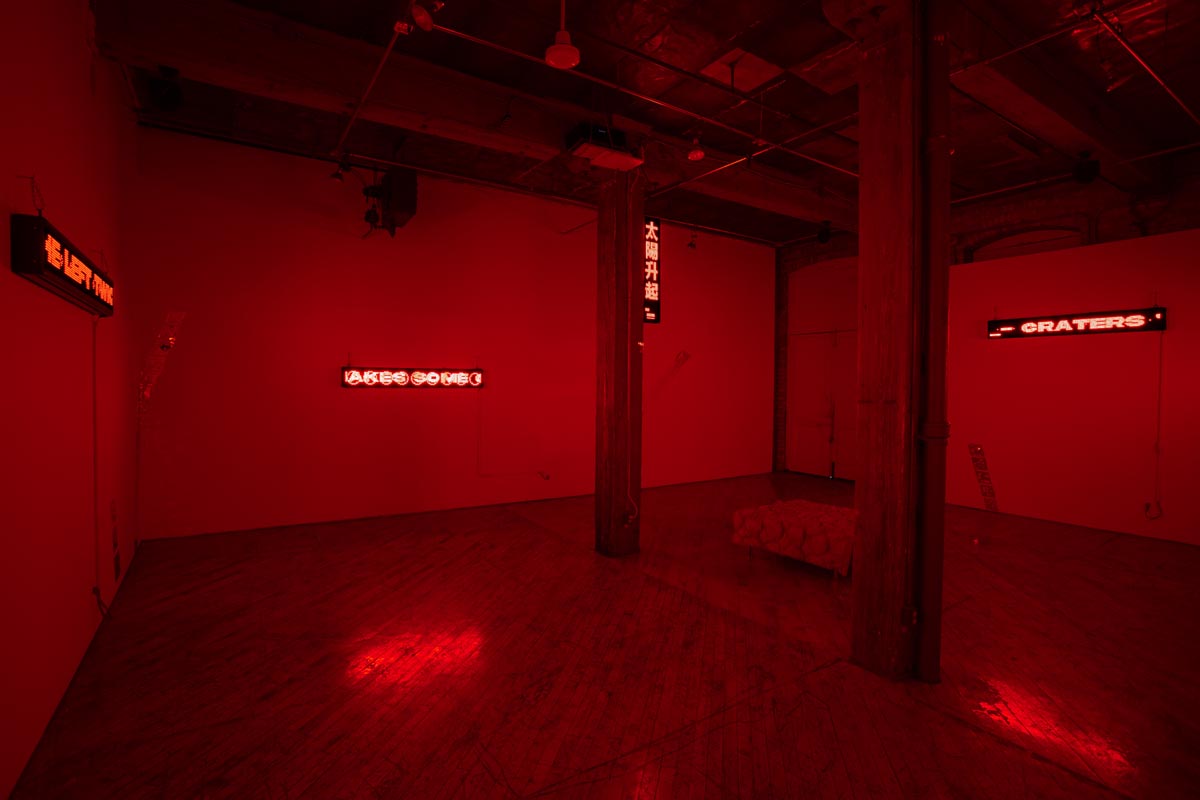 Installation View, red room, dim lights, with LED signs.