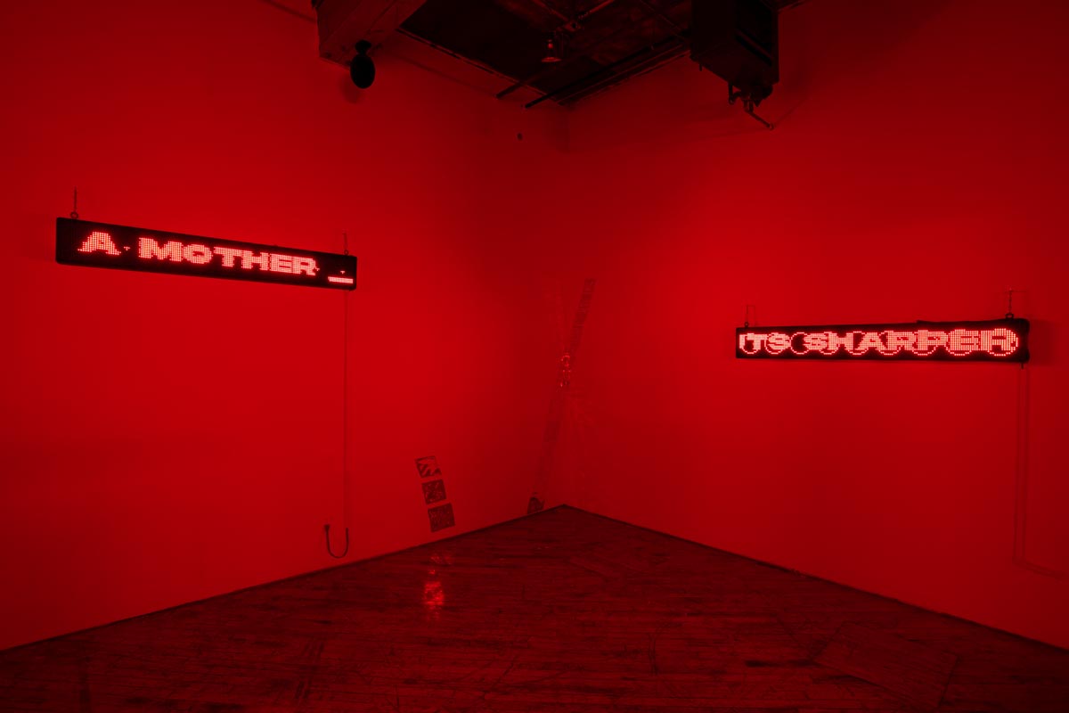 Installation View, red room, dim lights, with LED signs.