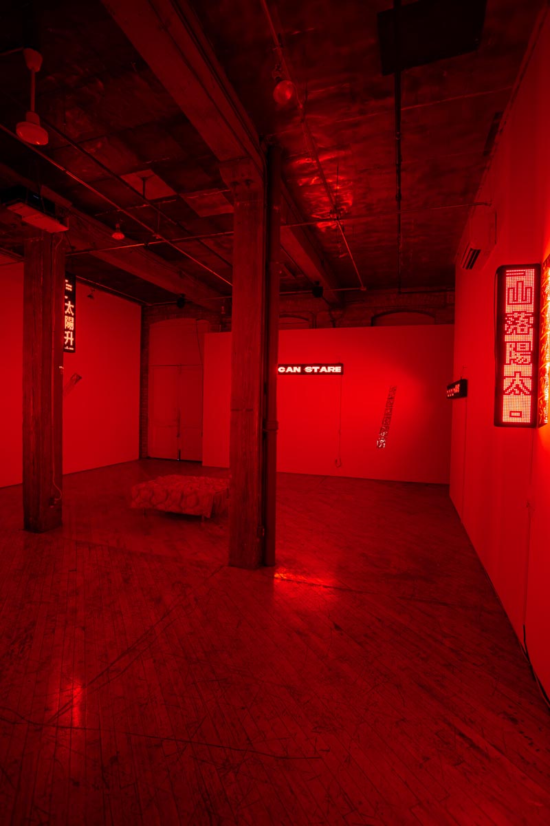 Installation View, red room, dim lights, with LED signs.