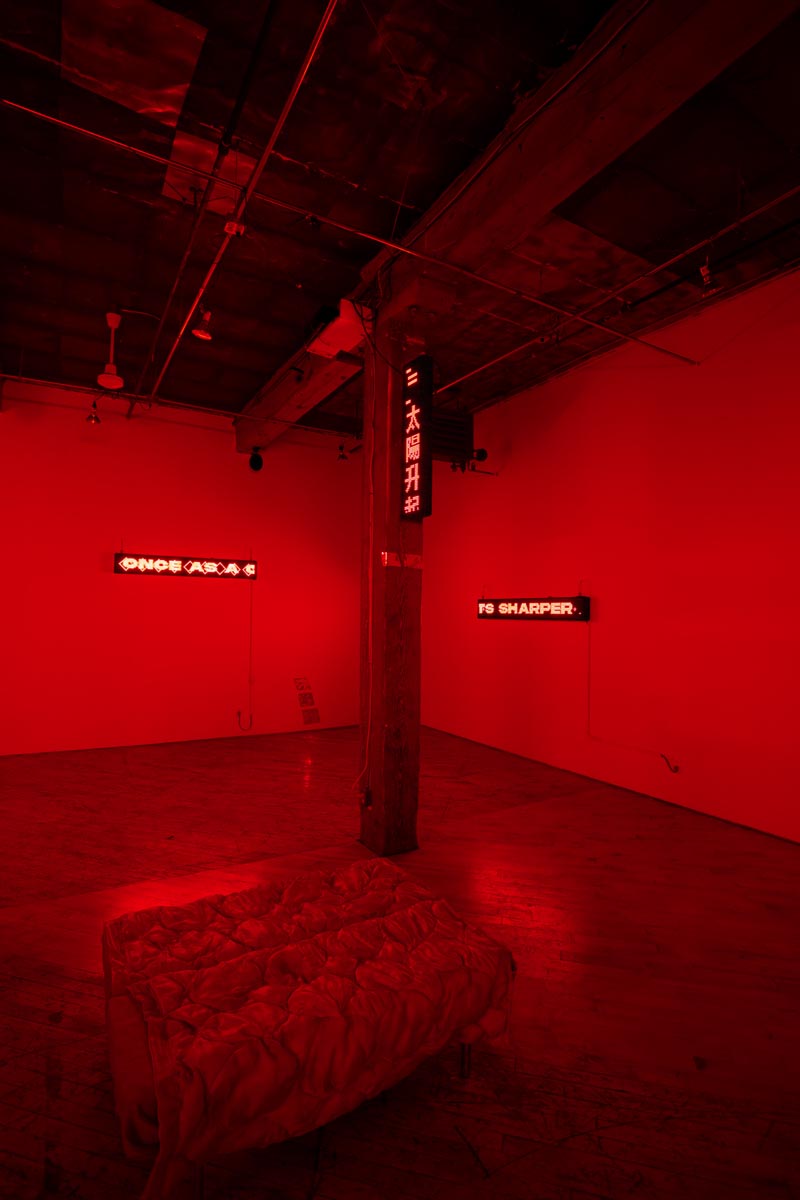 Installation View, red room, dim lights, with LED signs.