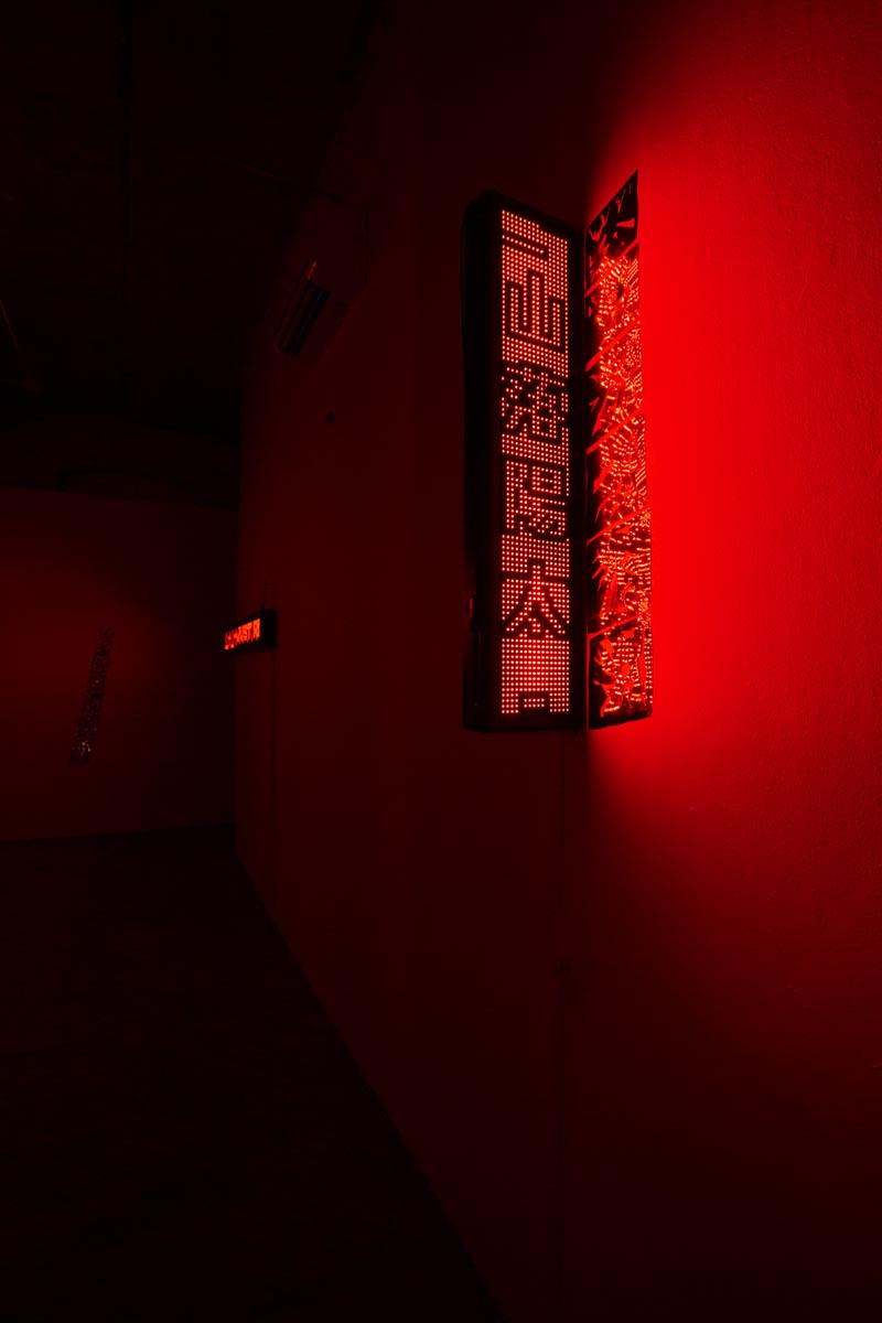 Installation View, red room, dim lights, with LED signs.