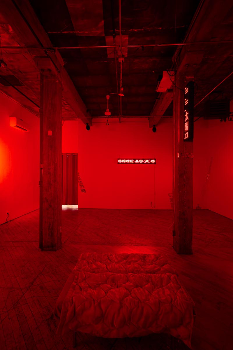 Installation View, red room, dim lights, with LED signs.